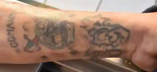El cadáver registra en su brazo izquierdo un tatuaje con la leyenda “COMANDO” y una calavera