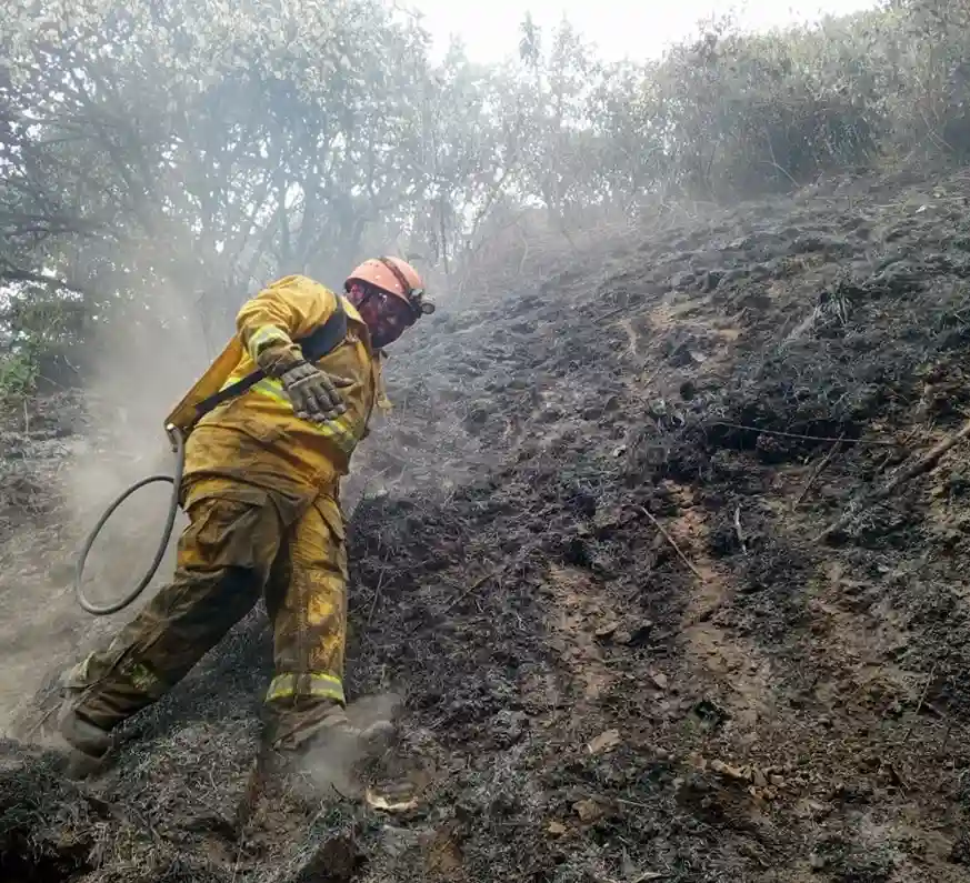 Bombero sofocando un incendio en Pallatanga.